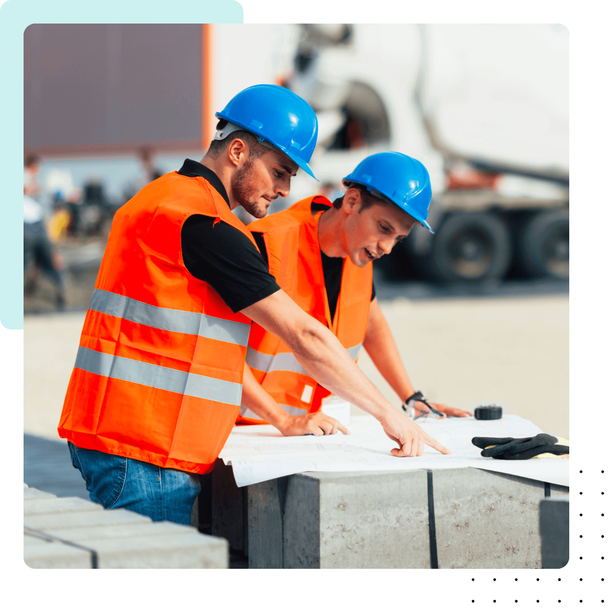 Two construction workers reviewing blueprints outdoors.
