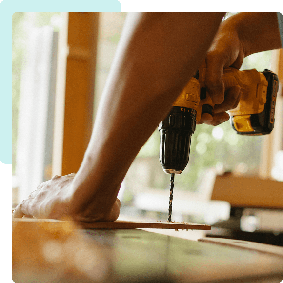 Person using a drill on wood.